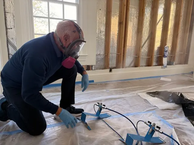 A restoration technician setting drying equipment in a St. Louis home stripped to the studs